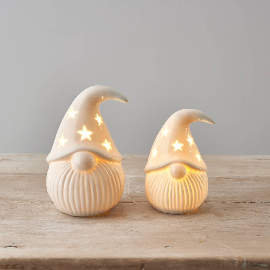 Two light-up gonk figurines on a wooden surface with a neutral background