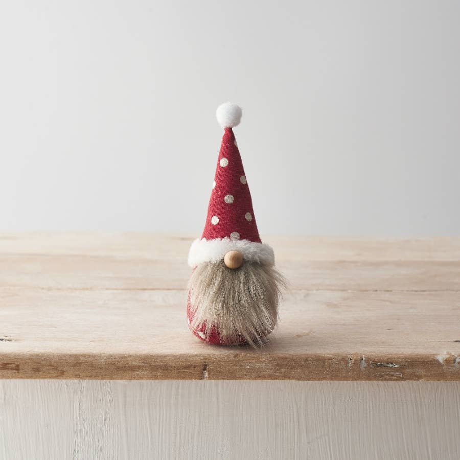 Small gnome figurine with a red hat on a wooden surface