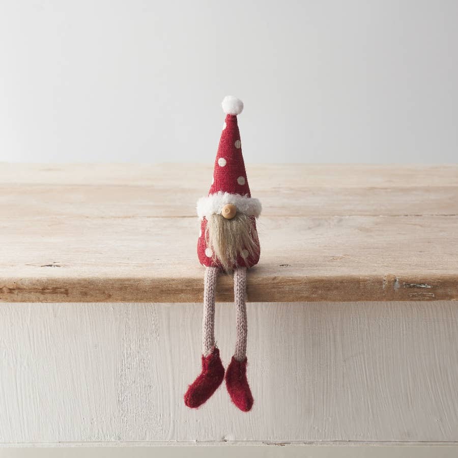 Gnome figurine with a red hat and shoes on a wooden surface