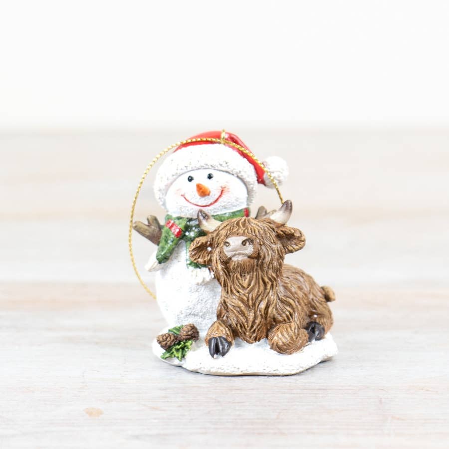Christmas ornament featuring a snowman with a highland cow and reindeer on a white background