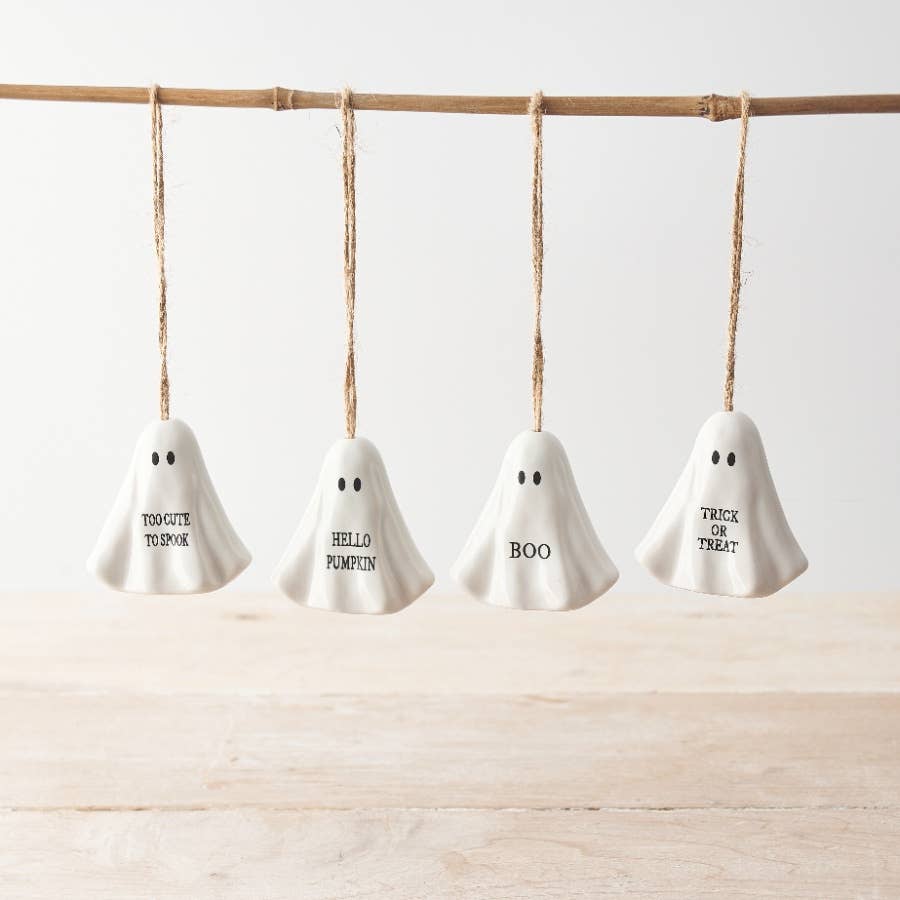 Four white ghost-shaped ornaments with Halloween text on each.