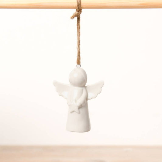 White ceramic angel ornament hanging on a wooden rod with twine against a white background