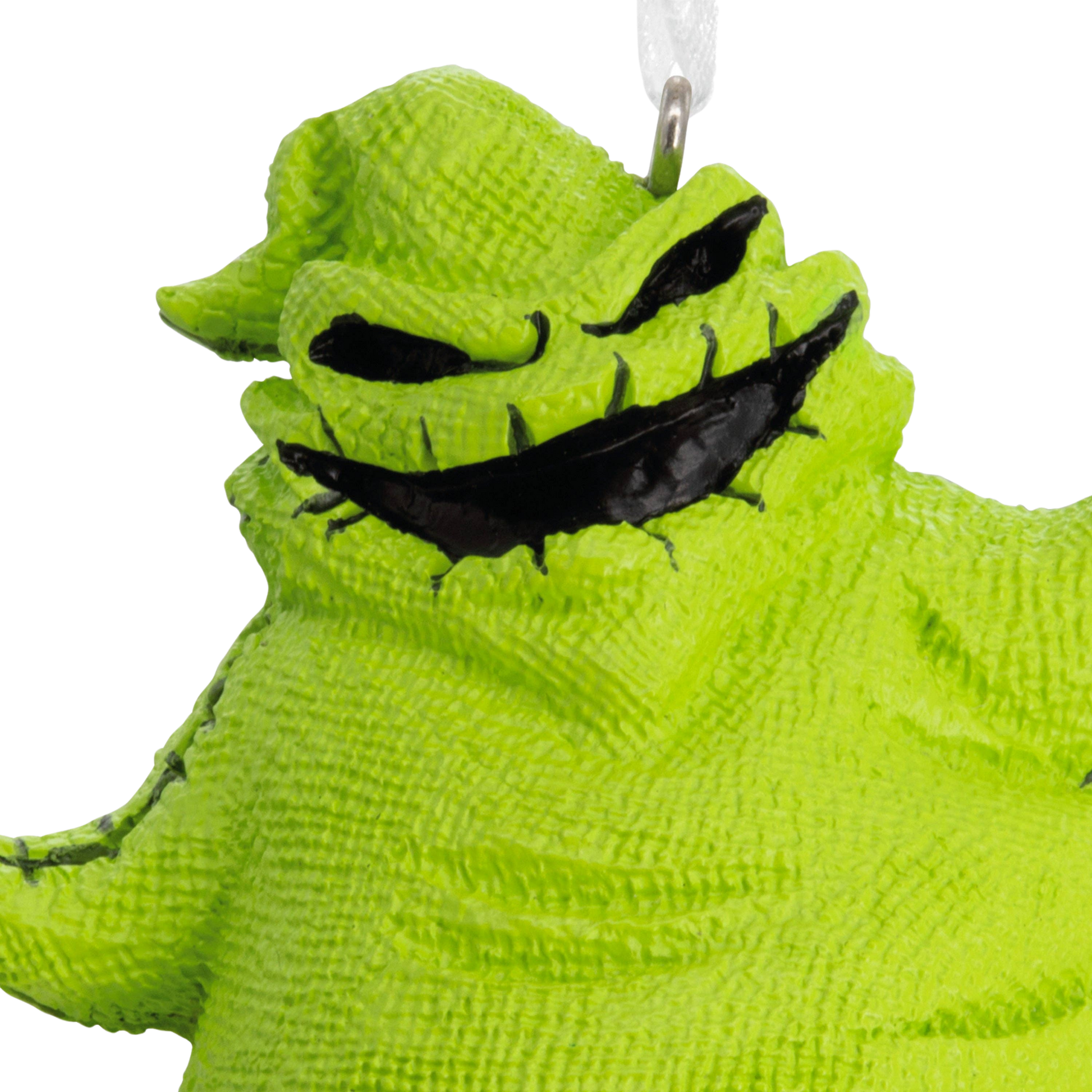 Disney The Nightmare Before Christmas Oogie Boogie Ornament close up of Oogie Boogie's green face with black stitched mouth. 