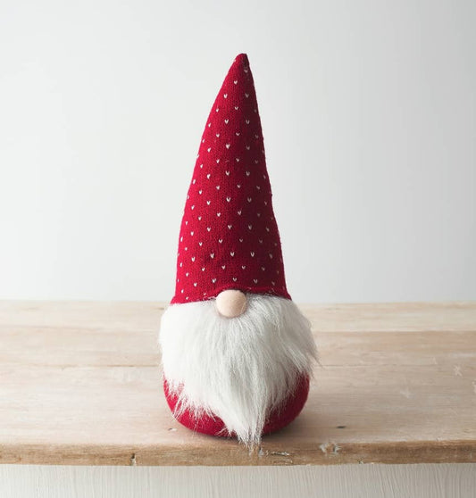 Red gnome figurine with white beard on a wooden surface