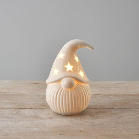 Decorative gnome figure with a light-up hat on a wooden surface