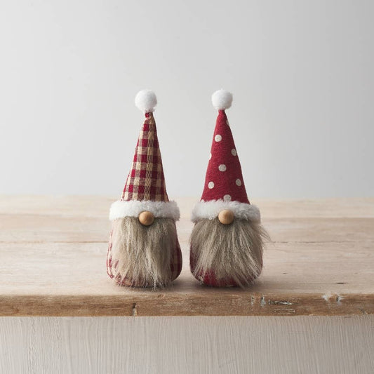 Two decorative gnomes with red hats on a wooden surface.