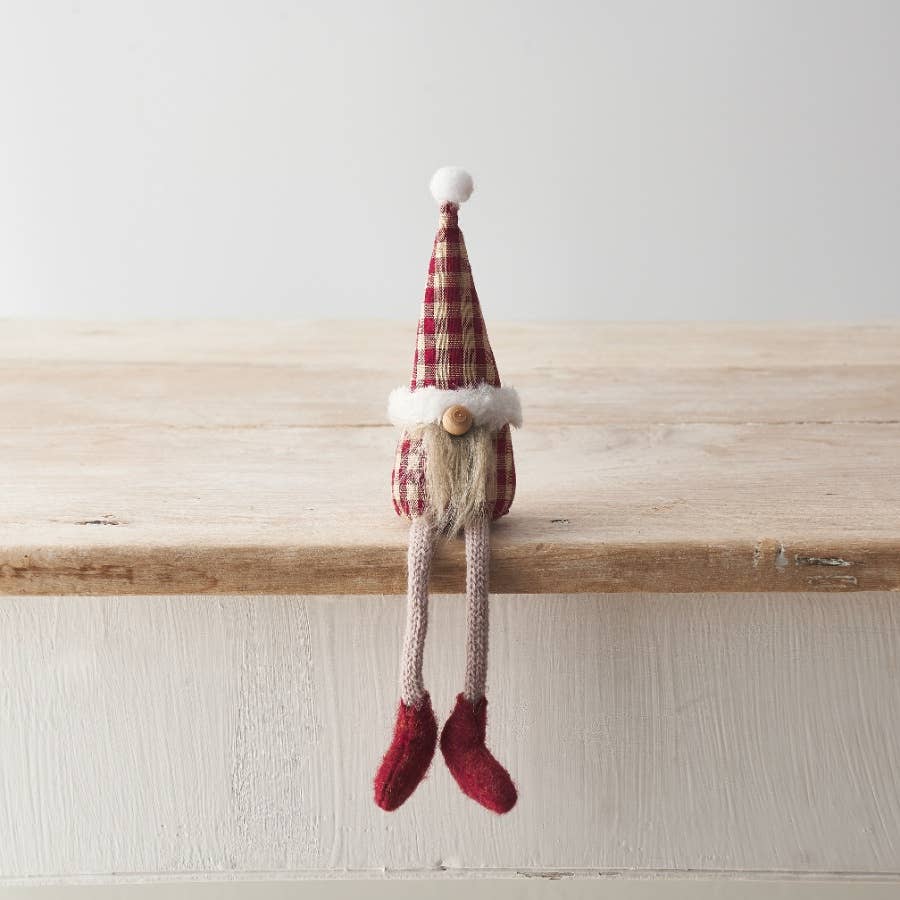 Decorative gnome with a gingham hat on a wooden shelf