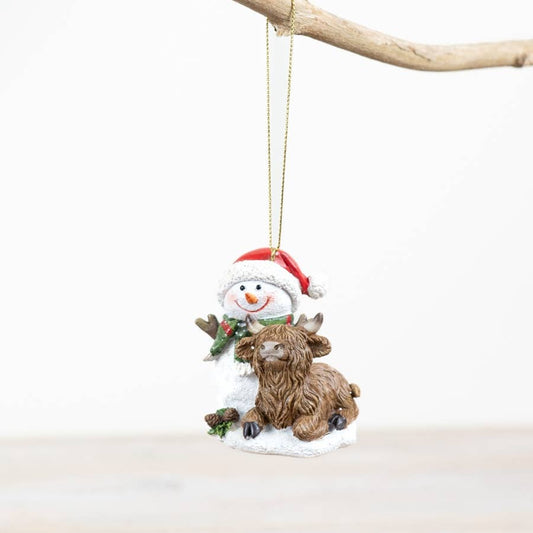 Decorative ornament with a highland cow and snowman on a white background