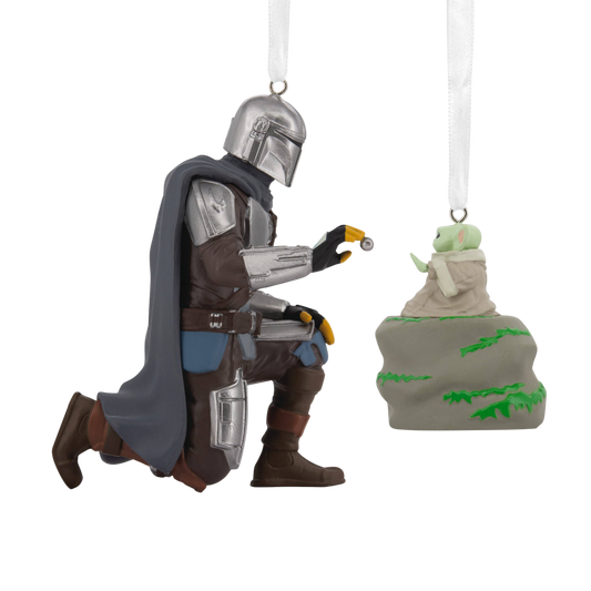 Two Christmas Star Wars ornaments of the Mandalorian kneeling and Grogu sitting on a rock.