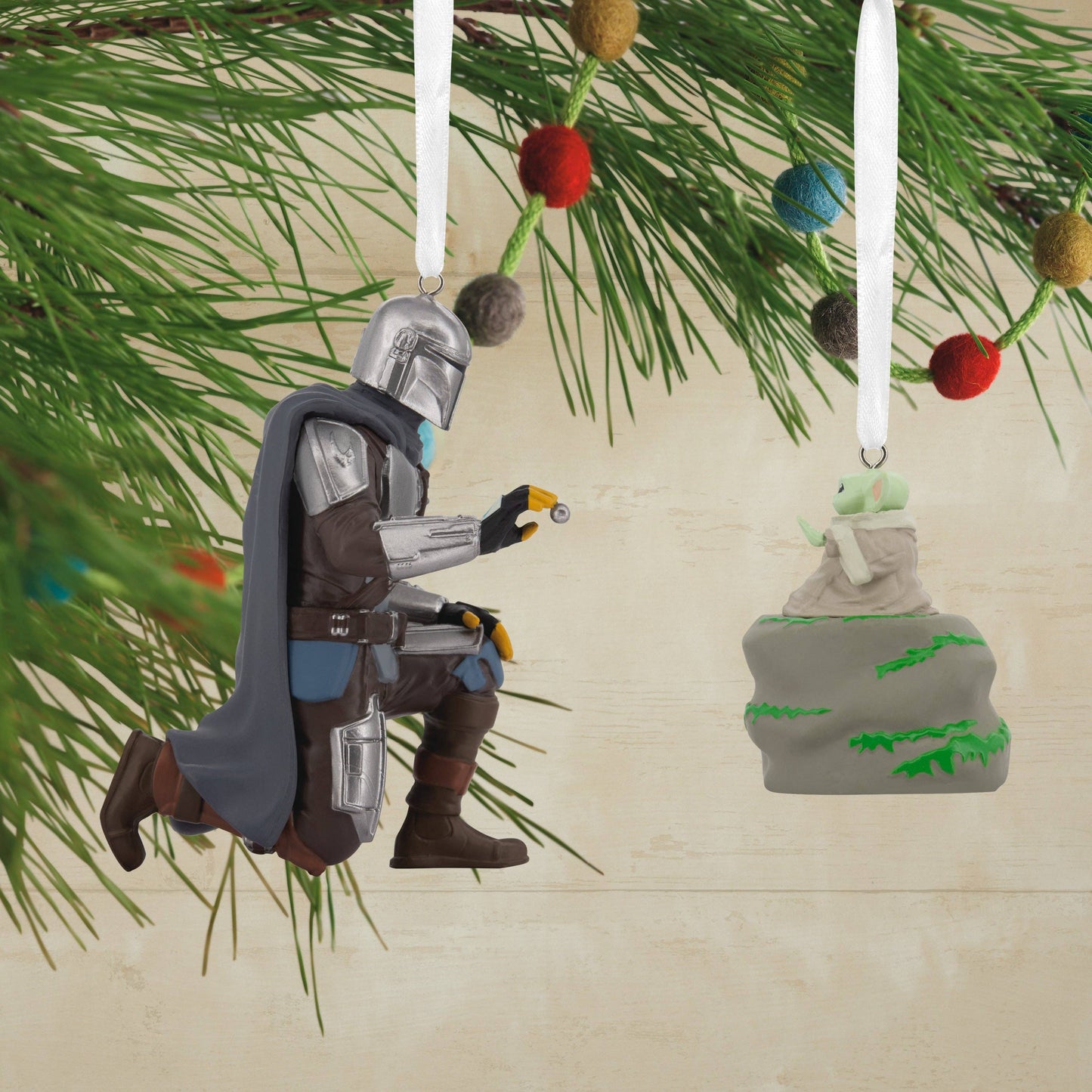Star Wars The Mandalorian and Grogu Christmas ornaments hanging from a Christmas tree. 