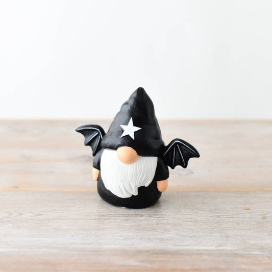 Gonk figurine with black hat, white beard, and star on a wooden surface