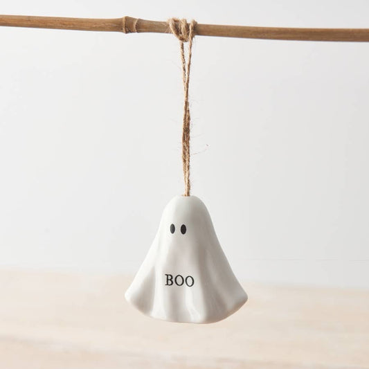 White ghost-shaped ornament with 'BOO' text hanging on a stick against a light background
