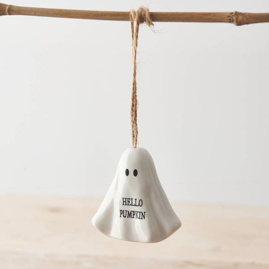 White ghost-shaped ornament with 'HELLO PUMPKIN' text hanging on a branch.